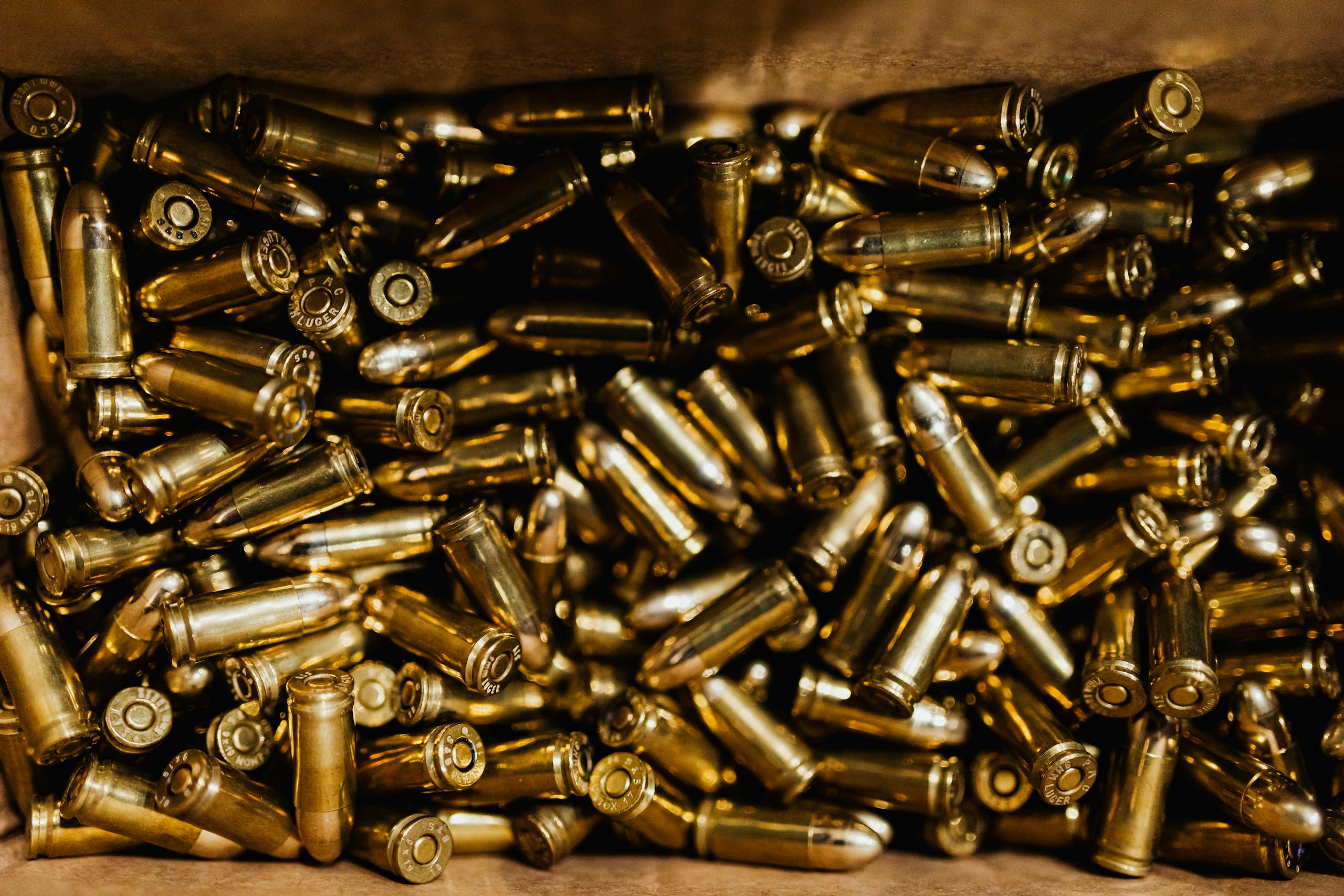 A close-up view of a collection of brass bullets inside a box, highlighting their shiny metallic texture.